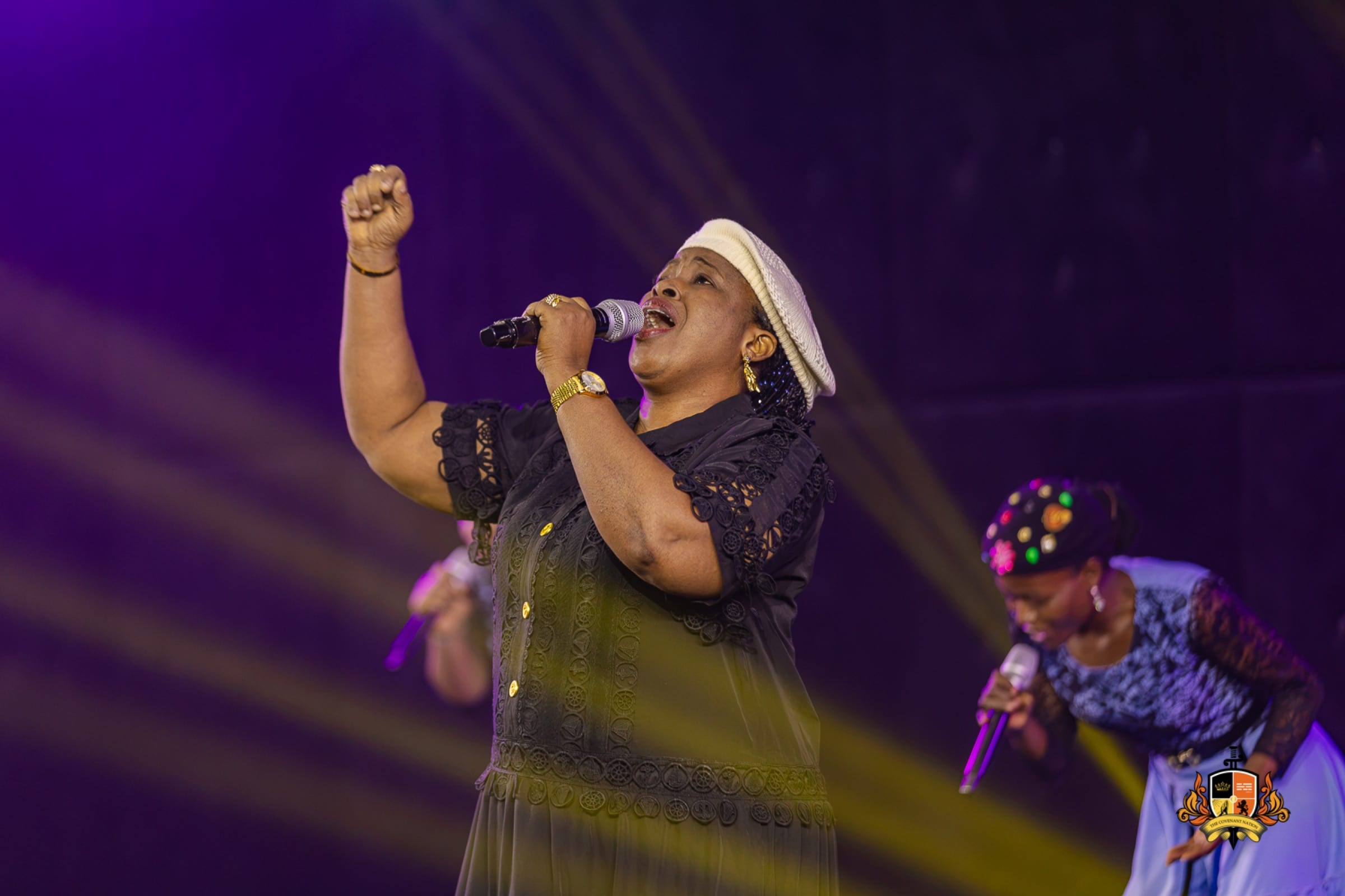 Minister Lilian Nneji leading high praise under stage lights